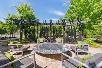 an outdoor patio with a fire pit and lounge chairs